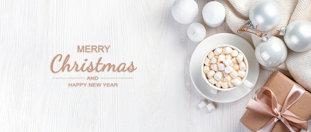 Foto kerstsamenstelling met koffie met marshmallows geschenken en kerstversieringen op een lichte achtergrond