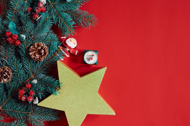 Kerstsamenstelling van dennenappels vuren takken en stapel geschenkdozen op rode achtergrond