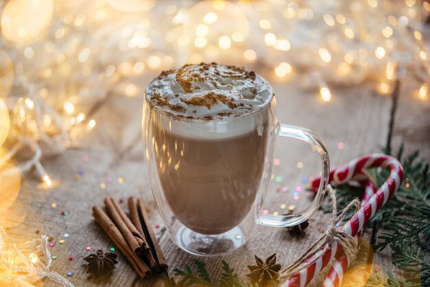 Foto kerstschoppende room, warme cacao met specerijen, snoepstokjes en thuja takken.