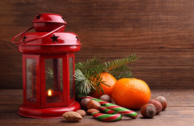 Kerstsfeer: noten, mandarijnen, kerstboom, noten, een zaklamp op een donkere houten achtergrond
