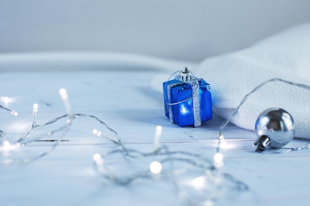 Kerstslinger met huidige doos op een blauwe houten achtergrond