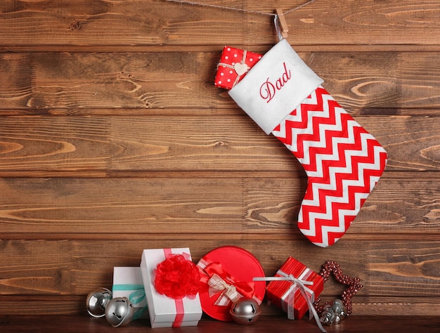 Kerstsok en cadeautjes tegen houten muur