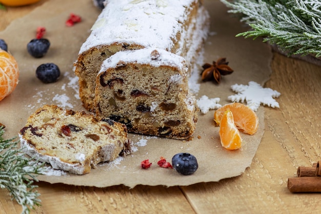 Kerststol met een mengsel van gedroogde vruchten, noten en poedersuiker op een plank