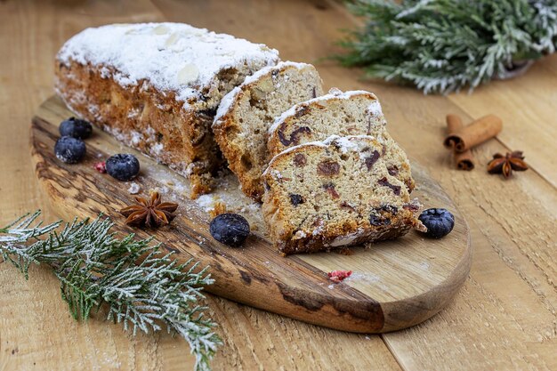 Kerststol met een mengsel van gedroogde vruchten, noten en poedersuiker op een plank