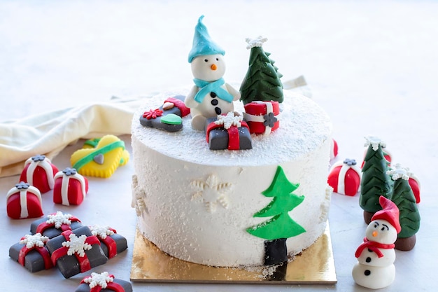 Kersttaart bereid met suikerpasta Met sneeuwpop Kerstboom en cadeaufiguren erop