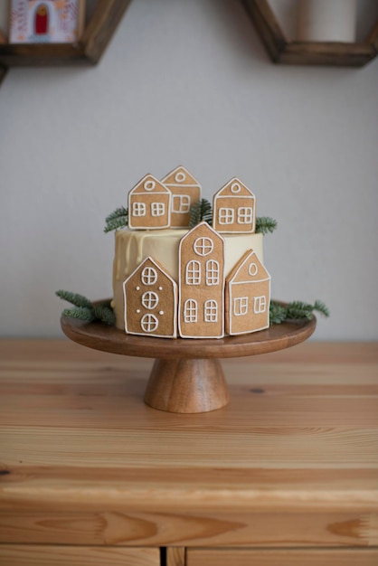 Kersttaart met peperkoekhuisjes op een houten standaard