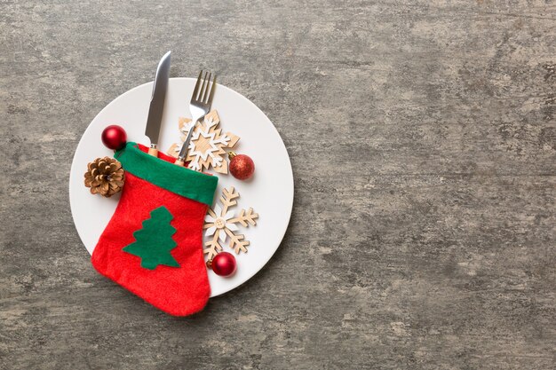 Kersttafel couvert met kerst decor en borden, kine, vork en lepel. Kerst vakantie achtergrond. Bovenaanzicht met kopieerruimte