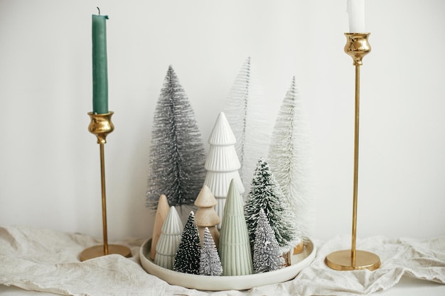 Kersttafel decor Stijlvolle kleine kerstbomen op bord linnen loper gouden kaarsen