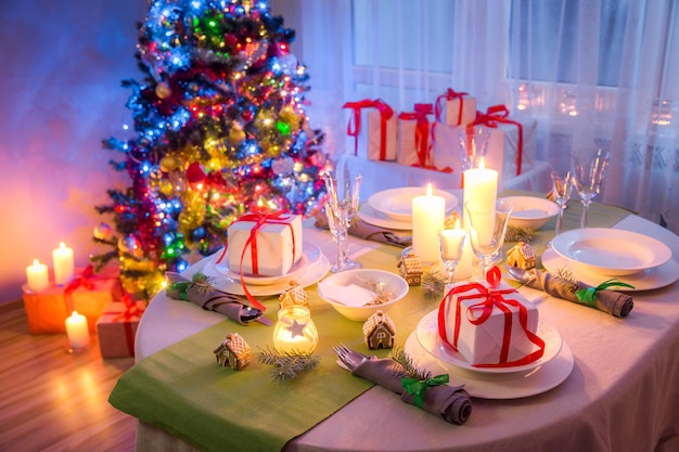 Kersttafel met groene en witte decoratie in de avond