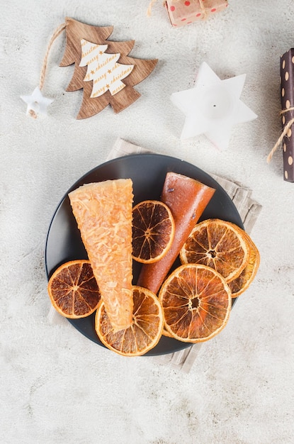 Kersttafel met lege zwarte plaat en houten versieringen en droge sinaasappelen