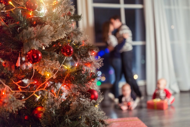 Kersttafereel met gelukkig gezin van vier boomgeschenken en raam