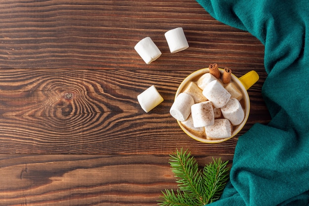 Kersttijd met kopje koffie en marshmallows naast wollen sjaal