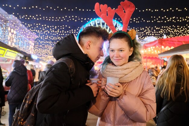 Kersttijd, nieuwjaarsvakantie. Jongeren, een paar tieners die plezier hebben op de kerstmarkt