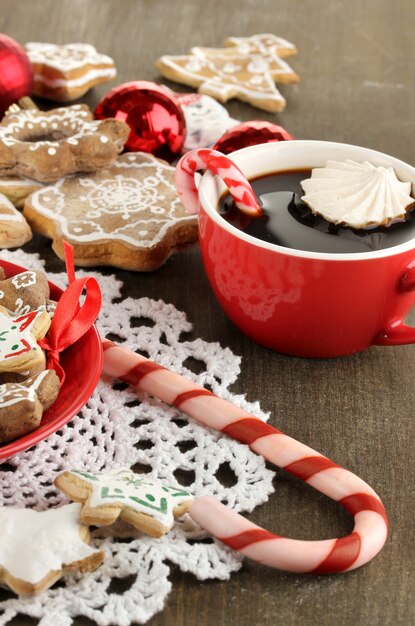 Kersttraktaties op bord en kopje koffie op houten tafel close-up