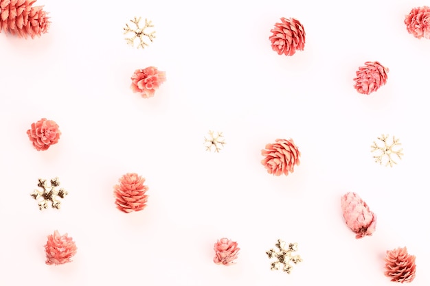 Kerstvakantie samenstelling van sneeuwvlokken en roze dennenappels. minimalistisch vakantieconcept
