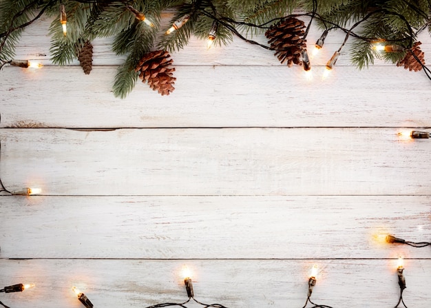 Kerstverlichting lamp en dennenbladeren decoratie op witte houten plank