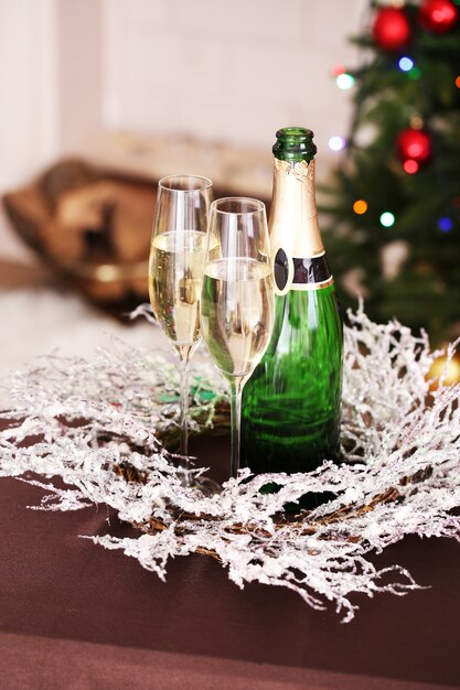 Kerstversiering en champagnefles en glazen op een helder oppervlak