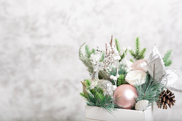 Kerstversiering geïsoleerd grijs. Witte geschenkdoos met kerstballen en bloemenornament