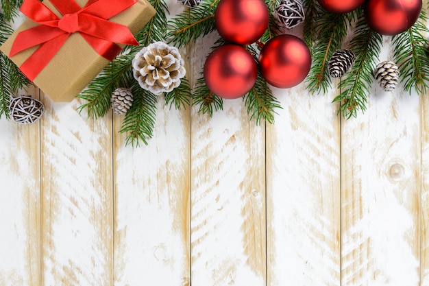 Kerstversiering, geschenkdoos en rode ballen op een witte houten tafel. Bovenaanzicht, kopie ruimte.