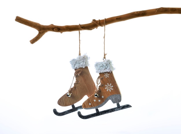 Kerstversiering in de vorm van een paar schaatsen die aan een boomtak hangen