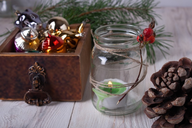 Kerstversiering in een houten kist, een kandelaar in een glazen pot