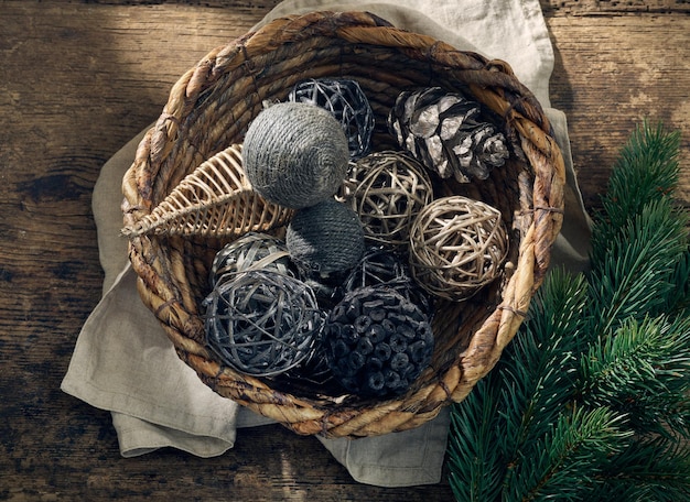 Kerstversiering in een rieten mand op oude houten tafel, bovenaanzicht