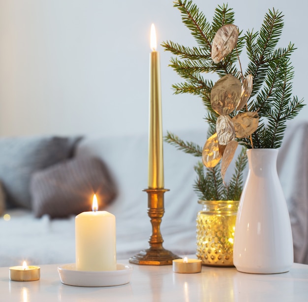 Kerstversiering met brandende kaarsen in wit interieur