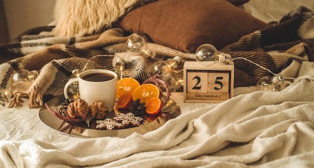 Kerstversiering met kopje thee, peperkoek en sinaasappelen