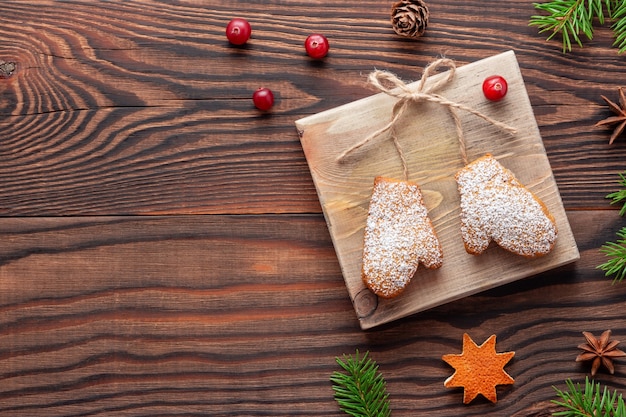 Kerstversiering of cadeau gemaakt van koekjes verbonden met touw op houten