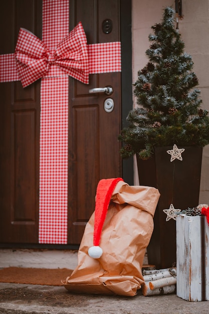 Kerstversiering van de veranda van het huis De toegangsdeur is versierd met een grote rode strik