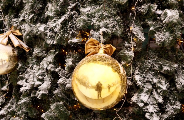 Kerstversiering van winkelcentrum bollen, bogen en takken van een dennenboom