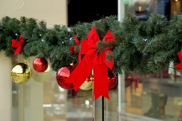 Kerstversiering van winkelcentrum bollen, bogen en takken van een dennenboom