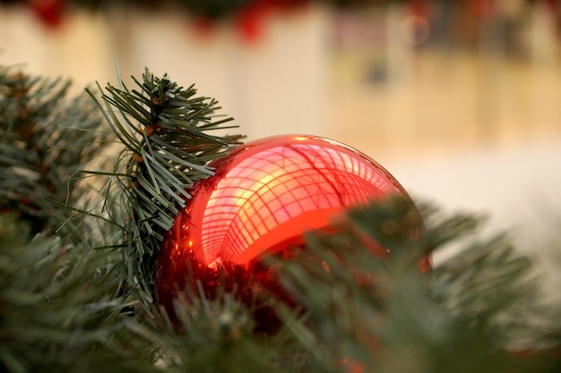 Kerstversiering van winkelcentrum bollen, bogen en takken van een dennenboom