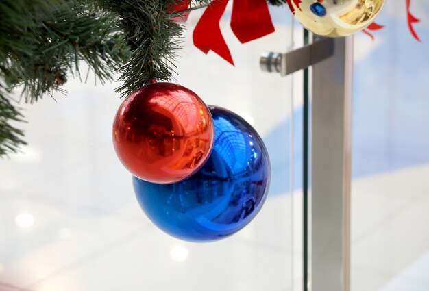 Kerstversiering van winkelcentrum bollen, bogen en takken van een dennenboom