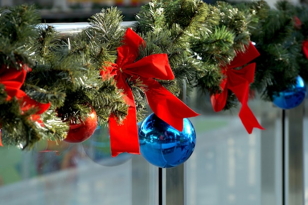 Kerstversiering van winkelcentrum bollen, bogen en takken van een dennenboom