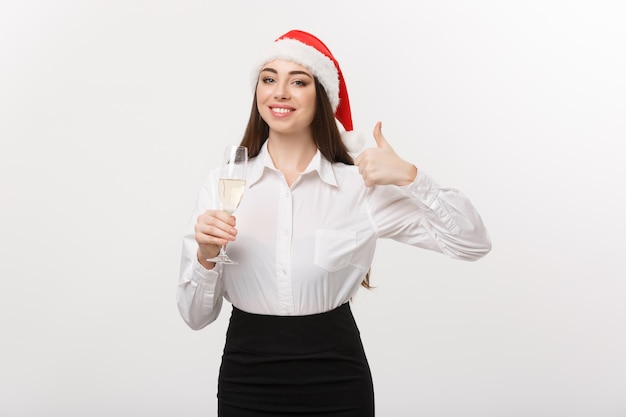 Kerstviering jonge mooie zakenvrouw vieren kerst met een glas champagne en duim opdagen