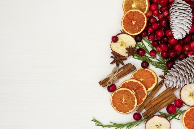 Kerstvoedsel op een witte achtergrond. Ingrediënten voor het koken - veenbessen, rozemarijn, sinaasappel en anijs op een witte achtergrond. Bovenaanzicht kopie ruimte.