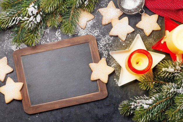 Kerstwenskaart met dennenboomkoekjes en kaarsen