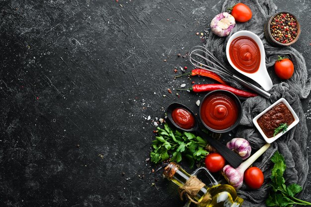 Ketchup chili sauce with tomatoes Hot red sauce On a black stone background