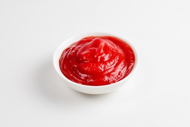 Ketchup in witte plaat op wit.