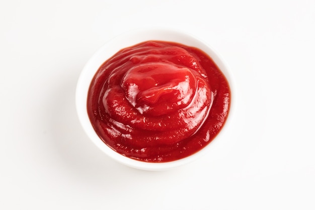 Ketchup in witte plaat op witte achtergrond.