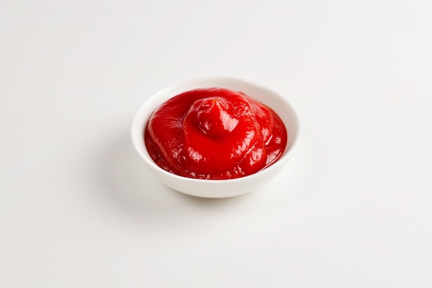 Ketchup in witte plaat op witte achtergrond