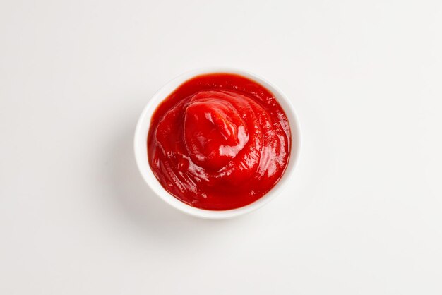 Ketchup in white plate on white background