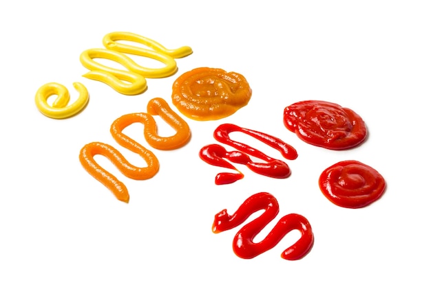 Ketchup e spruzzi di salsa gialla isolati su sfondo bianco.