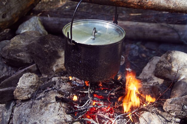 Ketel kookt op het vuur in het bos.