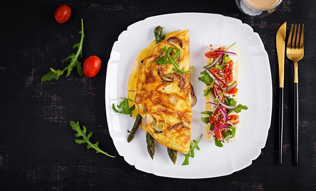 Foto colazione keto frittata con cipolla rossa al formaggio e asparagi sul tavolo scuro frittata italiana pranzo cheto chetogenico vista dall'alto spazio copia dall'alto