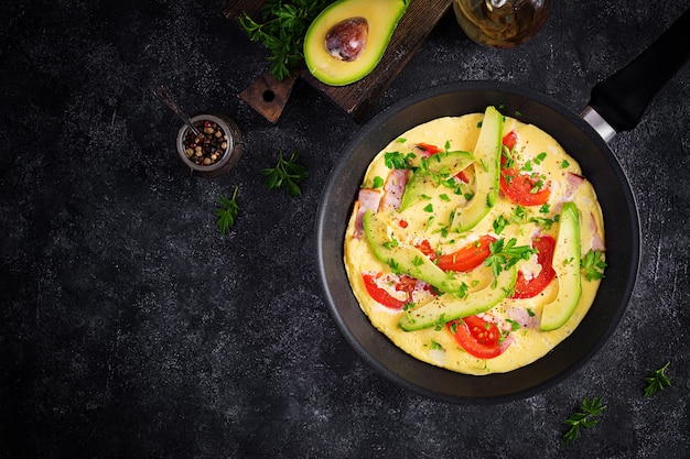 Keto breakfast. Omelette with ham,  tomatoes and avocado on grey table. Italian frittata. Keto, ketogenic lunch. Top view, overhead, copy space