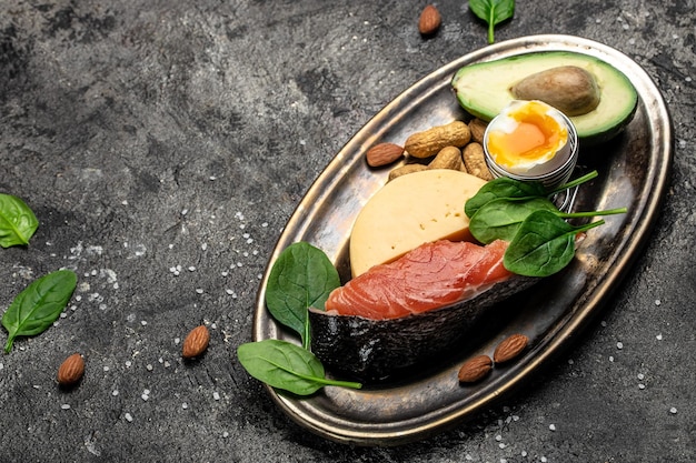 Keto dieet voedsel zalm avocado kaas ei spinazie en noten Ketogeen koolhydraatarm dieet concept Ingrediënten voor gezonde voeding selectie plaats voor tekst bovenaanzicht