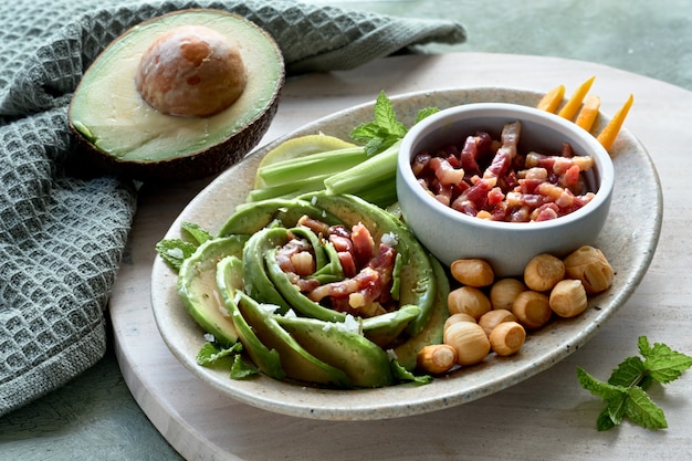 Keto diet, close-up on avocado rose salad with bacon cubes and smoked cheese