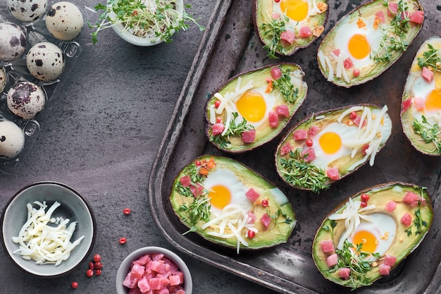 Keto diet dish: Avocado boats with ham cubes, quail eggs, cheese and cress sprouts 